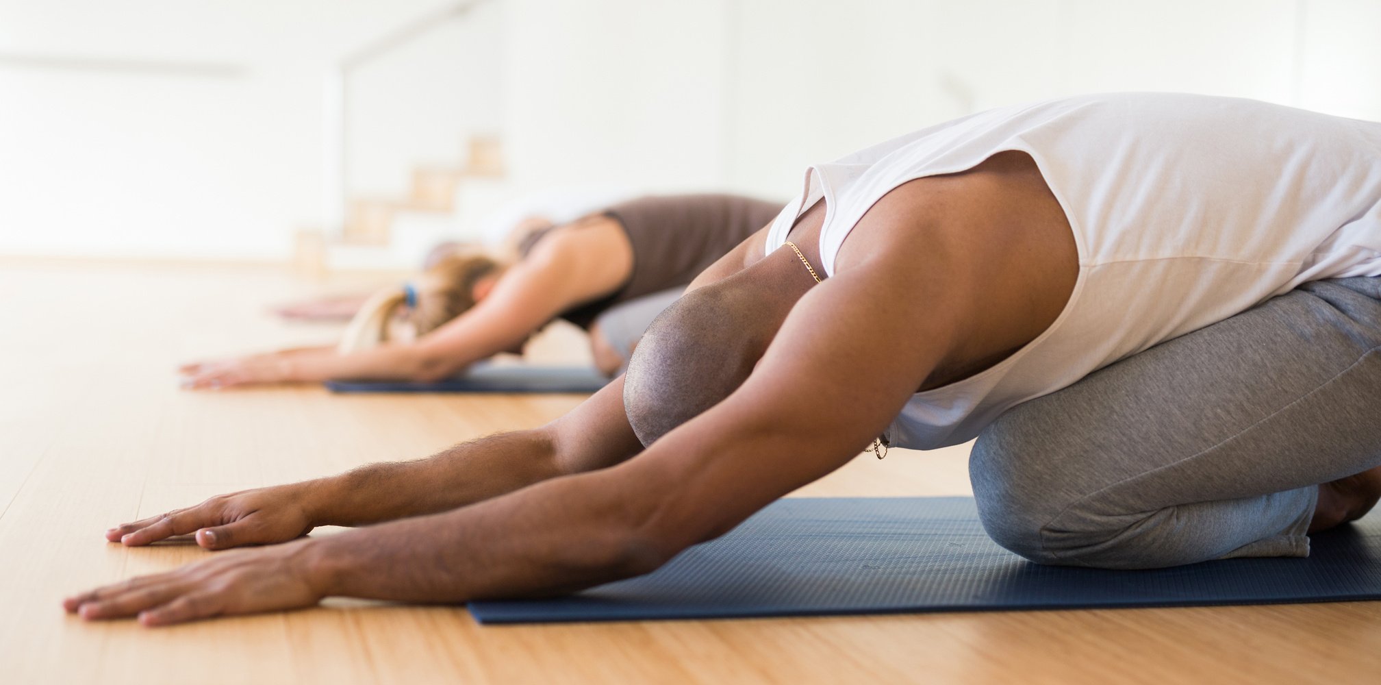 Woman and men stretching during group yoga training